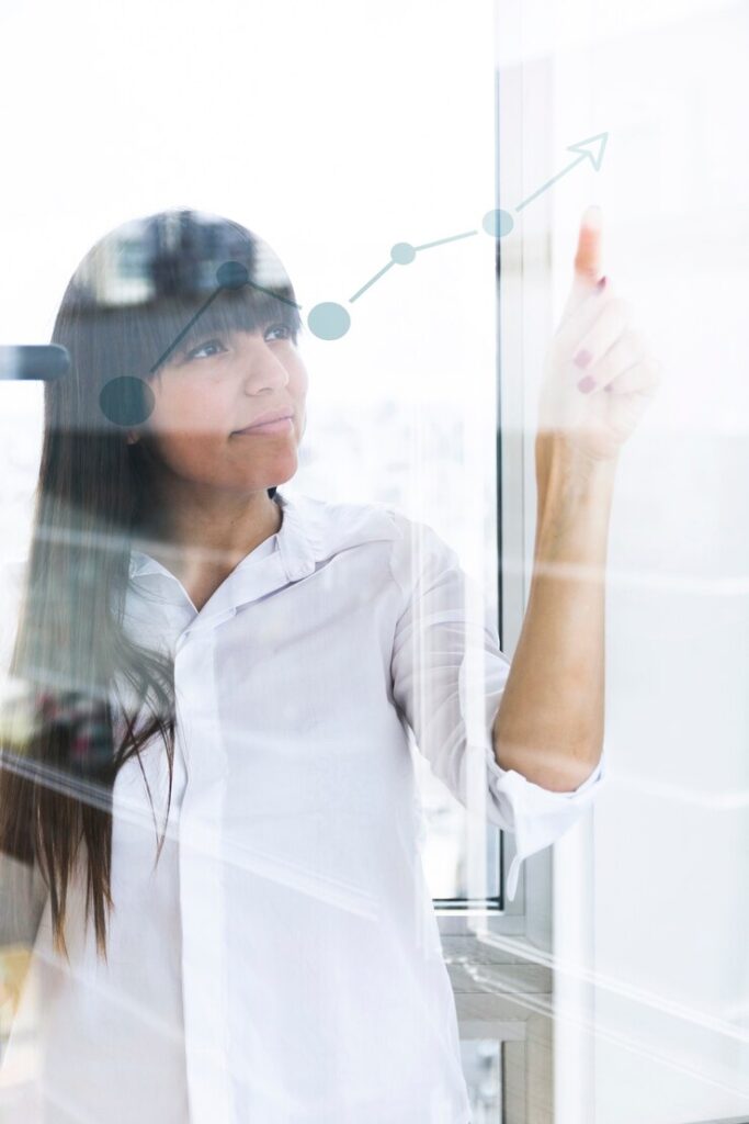 young-businesswoman-pointing-finger-increasing-graph-transparent-glass_23-2147857305
